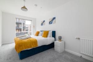 a bedroom with a blue and white bed and a window at Luxury Two Bed Apartment Near The 02 Arena in North Woolwich