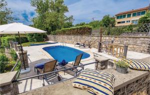 a patio with a pool and chairs and an umbrella at Gorgeous Home In Poljane With Sauna in Ružići +57 photos