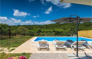 a pool with two chairs and an umbrella at Villa Laura Ripenda in Ripenda Kras