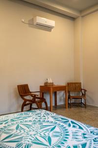 a bedroom with a bed and a table and chairs at Triton Dondra in Dondra West