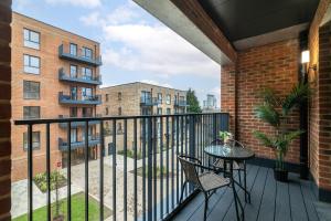 a balcony with a table and chairs and a building at Luxury Two Bed Apartment Near The 02 Arena in North Woolwich