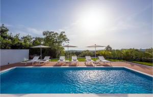 a swimming pool with chairs and umbrellas at Villa Eleven in Rovinj