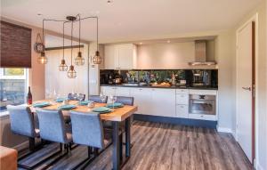 a kitchen with a wooden table and blue chairs at Oud Kempen Bungalow 99 in Stavenisse