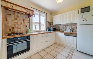 a kitchen with white cabinets and a window at Stunning Home In Bassan With Wifi in Bassan