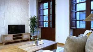 a living room with a television and a table at Apartamentos centro Vilagarcía in Vilagarcia de Arousa