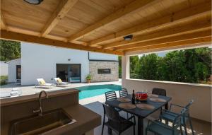 a patio with a table and a kitchen and a pool at Villa Stella Mare in Premantura