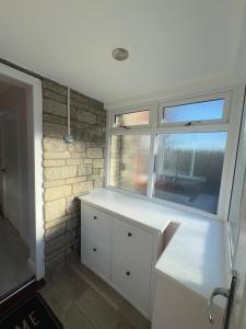 a kitchen with a white counter and two windows at JOY & House in Bristol +35 photos