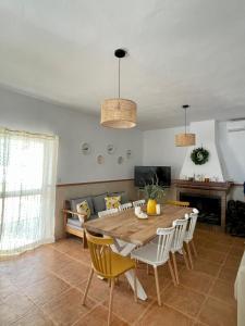 ein Wohnzimmer mit einem Holztisch und Stühlen in der Unterkunft Casa Rural El Almendro in Olvera + 11 Fotos