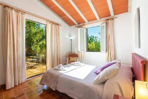 a bedroom with a bed and a large window at Can Miquel, villa in Pollensa in Pollença