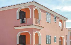a pink building with white windows and shutters at Quadri in Orosei