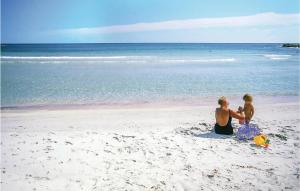 a man and a child sitting on the beach at Quadri in Orosei