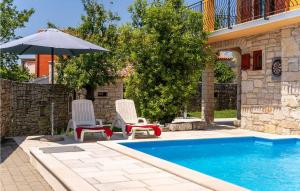 deux chaises et un parasol à côté d'une piscine dans l'établissement Villa Zaneta, à Vošteni