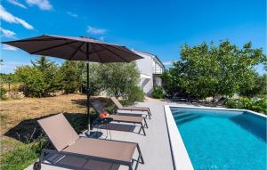 a swimming pool with lounge chairs and an umbrella at Villa Black Wood in Zadar