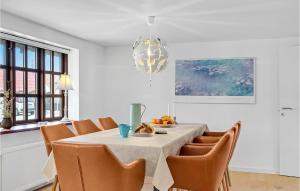 a dining room with a table with chairs and a chandelier at 2 Bedroom Beautiful Home In Løkken in Løkken