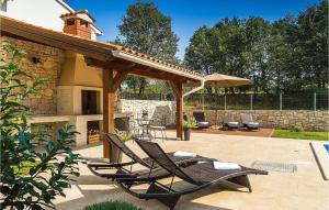 een patio met 2 ligstoelen en een open haard bij Villa Natasha in Ružići