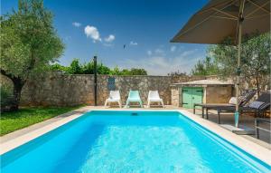 a swimming pool with two chairs and an umbrella at Villa Kalu in Rovinj