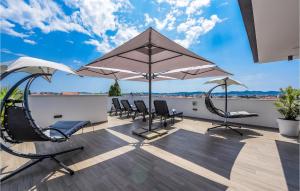 Un patio con sillas y sombrillas en una terraza. en Villa La Vie, en Zadar