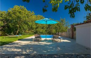 two chairs and an umbrella next to a pool at Villa Casa Mira in Vižinada