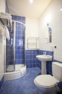 a blue tiled bathroom with a toilet and a sink at Marton Olimpic in Kaliningrad