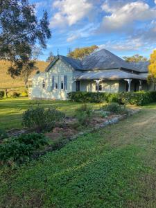 a white house with a yard in front of it at Loretta- a rustic country cottage in Brookfield