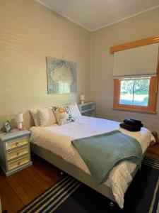 a bedroom with a bed and a window at Loretta- a rustic country cottage in Brookfield