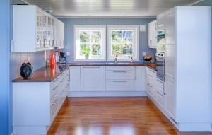 Vakaにある5 Bedroom Lovely Home In Ølensvågの白いキャビネットと木製の床を備えたキッチン