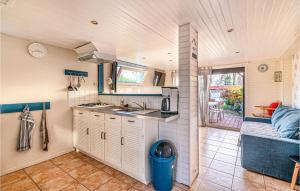 una pequeña cocina con fregadero y sofá en Awesome Home In Criquetot-L'esneval, en Criquetot-lʼEsneval