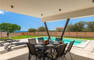 a table and chairs on a patio with a pool at Villa Ogradina in Pula