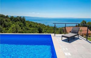 une chaise assise à côté d'une piscine bleue dans l'établissement Villa Ziganto, à Opatija 52 autres photos
