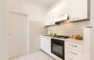 a kitchen with white cabinets and a black stove top oven at Apartment Fazana 09 in Fažana