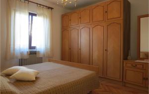 a bedroom with a bed and wooden cabinets and a window at Mariza in Rošini