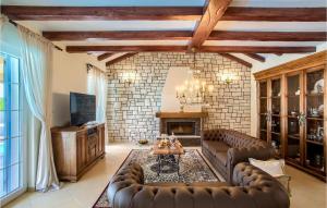 een woonkamer met leren banken en een open haard bij Villa Mek in Zadar