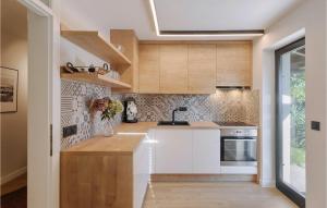 une cuisine avec des comptoirs blancs et des armoires en bois dans l'établissement Villa Aavaas, à Pula