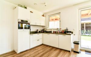 Una cocina blanca con gabinetes blancos y una ventana. en Maroma Regal, en Kamperland