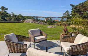 un gruppo di sedie e un tavolo su un patio di 4 Bedroom Gorgeous Home In Tromøya a Veden Altre 34 foto