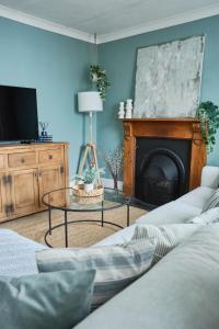 a living room with a couch and a fireplace at Beautiful Town House in Stratton, Bude, Sleeps 8 in Bude