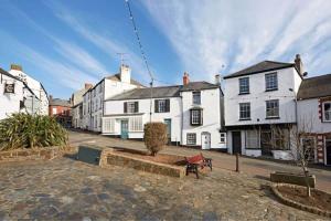 a city street with white houses and a bench at Beautiful Town House in Stratton, Bude, Sleeps 8 in Bude