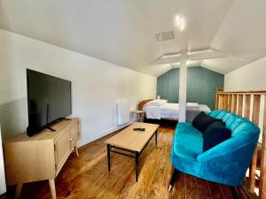 a living room with a blue couch and a bed at Duplex Aristide Briand 5 min gare-DABNB in Limoges