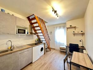 a kitchen with a sink and a staircase in a room at Duplex Aristide Briand 5 min gare-DABNB in Limoges
