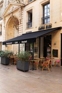 a restaurant with tables and chairs in front of a building at CENTRAL Hôtel Bordeaux Centre in Bordeaux
