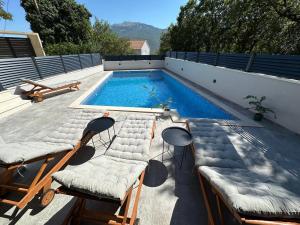 a swimming pool with lounge chairs and a swimming pool at Apartman Ivan with pool in Zagvozd
