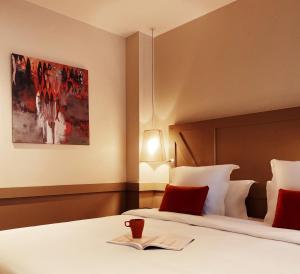 a hotel room with a bed with a book on it at La Maison des Armateurs in Saint Malo
