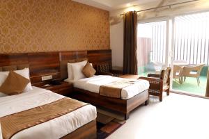 a hotel room with two beds and a balcony at Airport Hotel in New Delhi