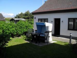 een tafel en een blauwe stoel in een tuin bij Kiekin in Wenningstedt