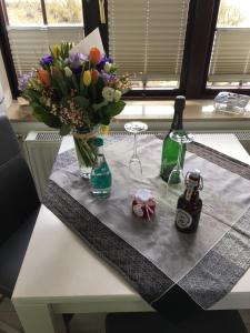 een tafel met een vaas met bloemen en twee flessen bij Kiekin in Wenningstedt +20 foto's