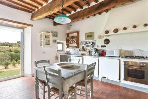 a kitchen with a table and chairs in a kitchen at Podere Mosciano in Marcialla