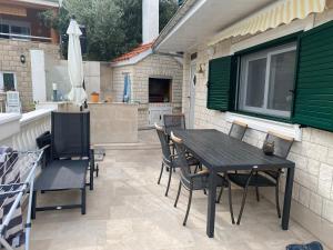 eine Terrasse mit Tisch, Stühlen und Sonnenschirm in der Unterkunft Oktobus in Rogoznica