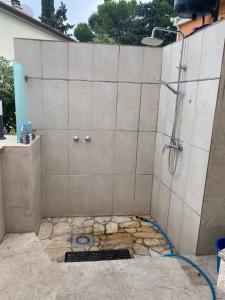 eine Dusche mit einem Schlauch an einer gefliesten Wand in der Unterkunft Oktobus in Rogoznica + 4 Fotos