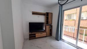 a living room with a tv and a large window at Apartamento Centro Benidorm 1 IF Benidorm in Benidorm