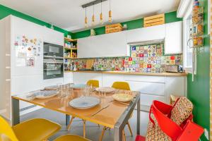 a kitchen with a wooden table and chairs at La Casita Mexicana - Kids Friendly by So Homy- 3 Bed Room - 6 PAX in Saint-Ouen